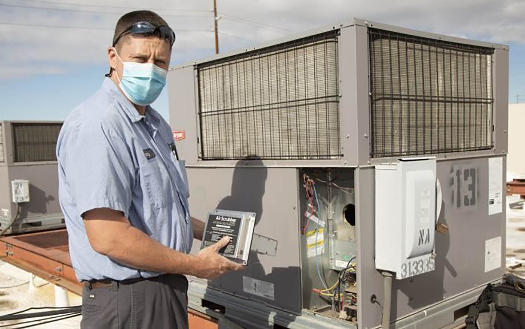 an air conditioning mechanic works on a unit