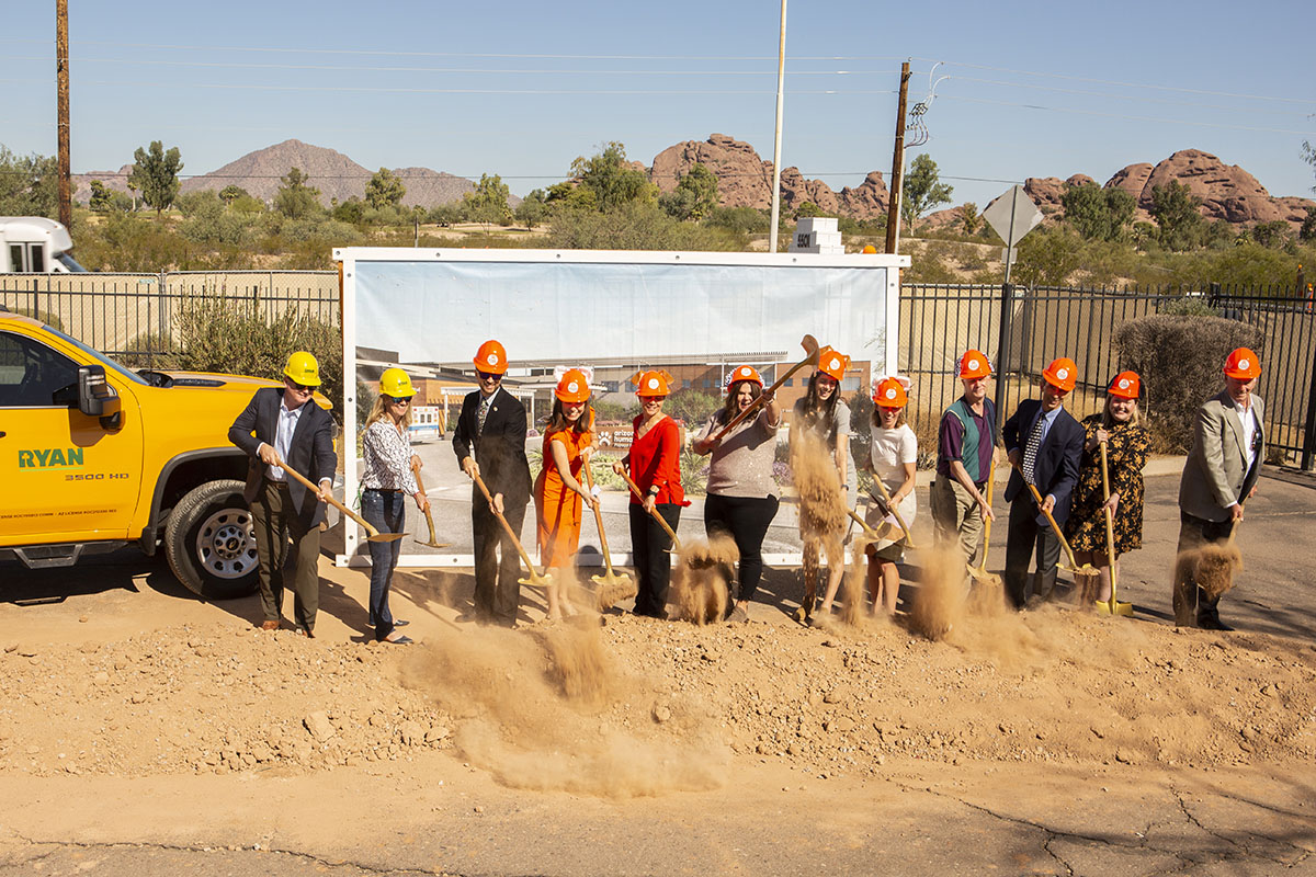 Staff and others lifting dirt at groundbreak