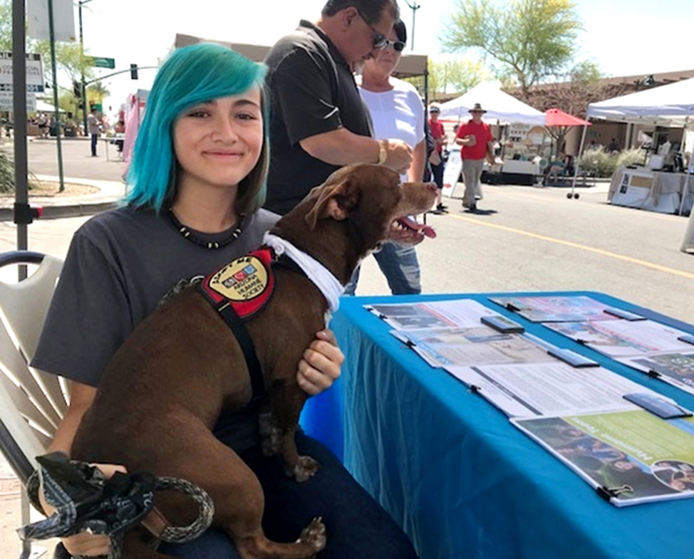 teen with dog at information booth