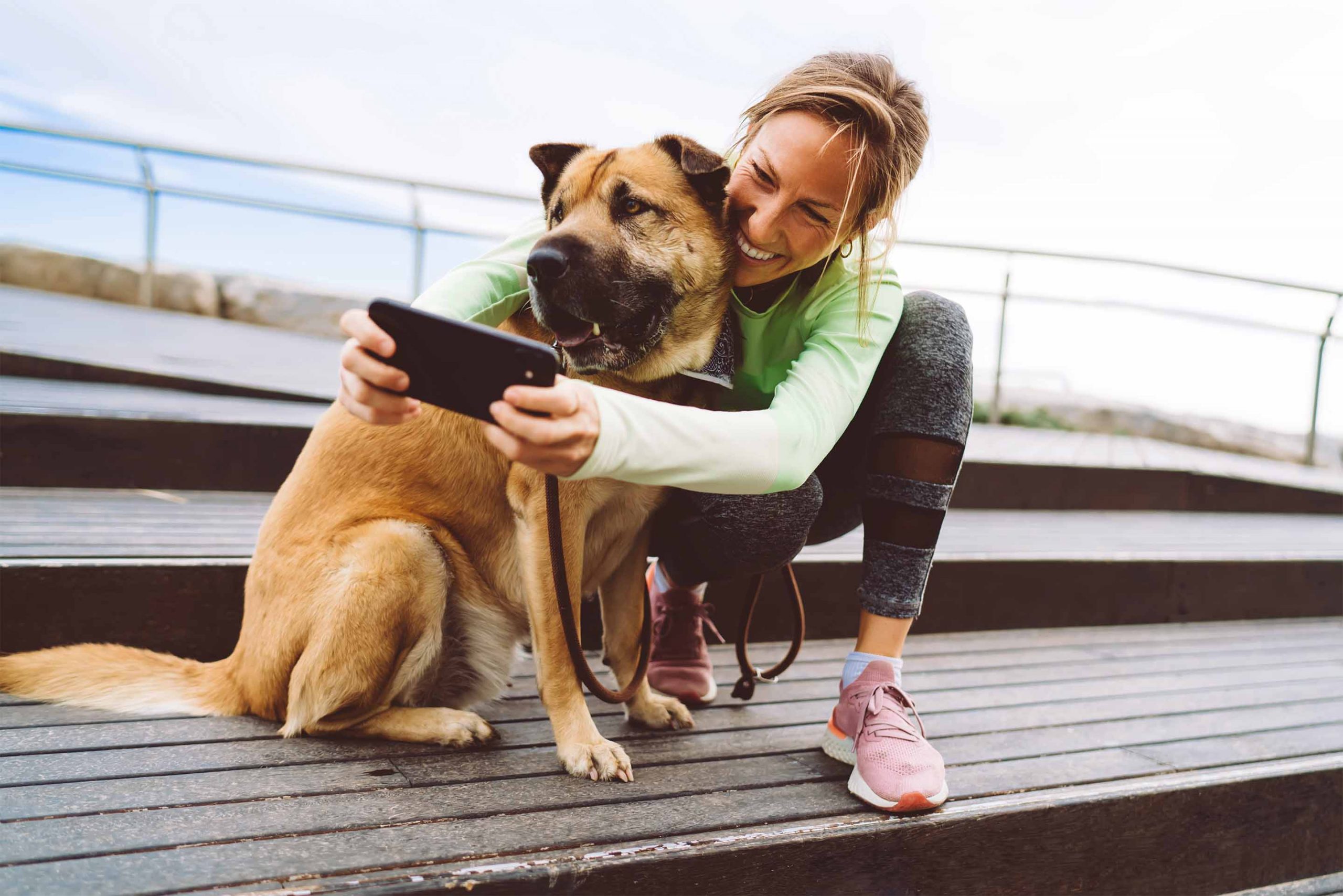 a woman poses with a large dog